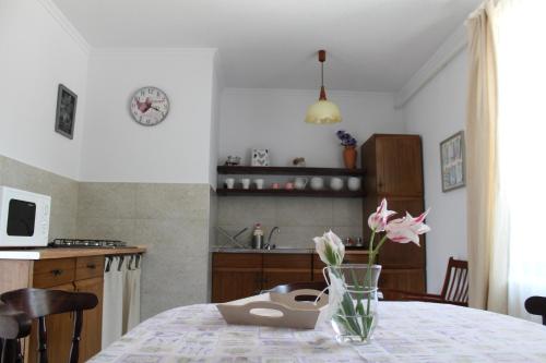 a kitchen with a table with a vase of flowers on it at Apartman Nikol in Tihany