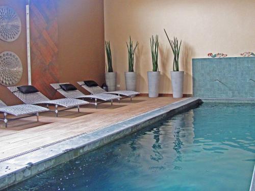 a swimming pool with lounge chairs next to a building at Hotel Itapemar - Ilhabela in Ilhabela