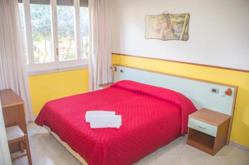 um quarto com uma cama com um cobertor vermelho em Villa Speranza em Marausa