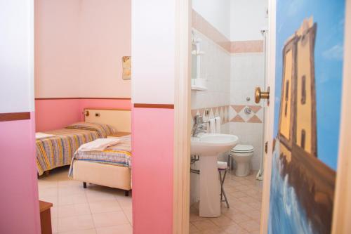 a small room with two beds and a sink at Villa Speranza in Marausa