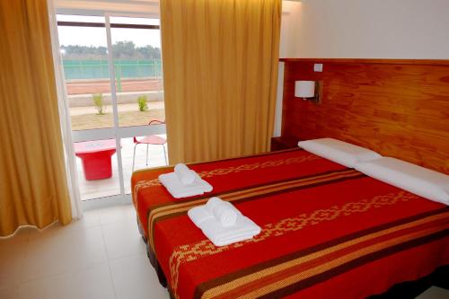 a hotel room with two beds and a window at Amérian Villa del Dique in Villa del Dique