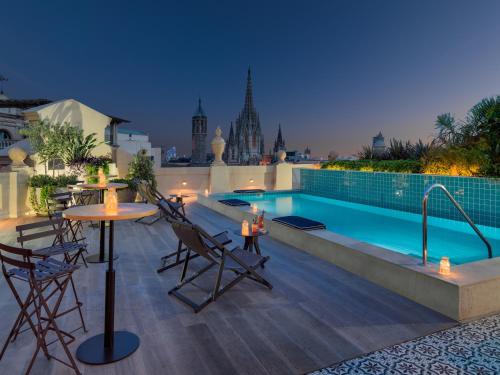 a large swimming pool with a balcony overlooking a city at H10 Madison 4* Sup in Barcelona
