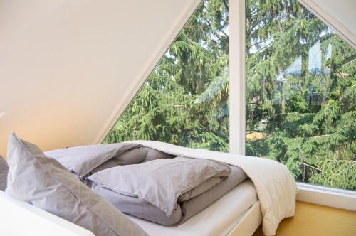Schlafzimmer mit einem großen Fenster und einem Bett mit Kissen in der Unterkunft Loft auf der Lohe in Bad Oeynhausen