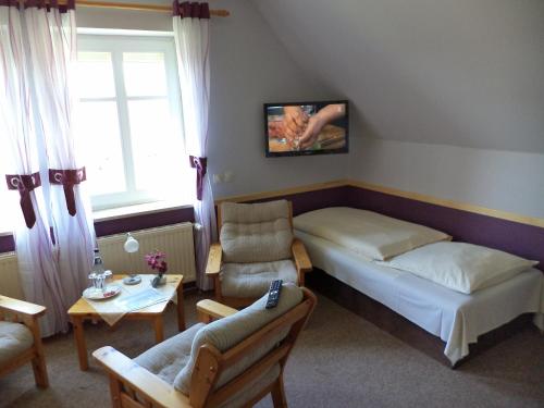 a bedroom with a bed and a couch and a table at Landgasthof Fegetasch in Neukirchen