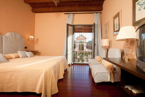 a hotel room with two beds and a window at Hotel Rural Posada del Moro in Cazalla de la Sierra