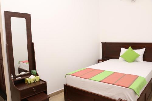 a bedroom with a bed and a mirror at Kandy City Village in Kandy