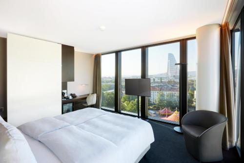 a hotel room with a bed and a large window at Hyperion Hotel Basel in Basel