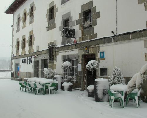 a group of chairs in the snow in front of a building at Hostal Rural Elosta in Lekunberri