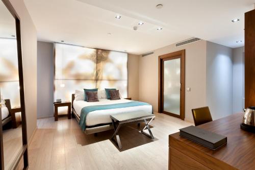 a hotel room with a bed and a desk at Hotel España Ramblas in Barcelona