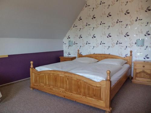 a bedroom with a wooden bed with birds on the wall at Landgasthof Fegetasch in Neukirchen