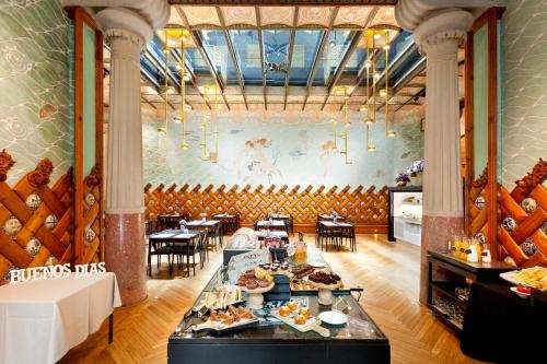 un ristorante con tavolo e cibo sopra di Hotel España Ramblas a Barcellona