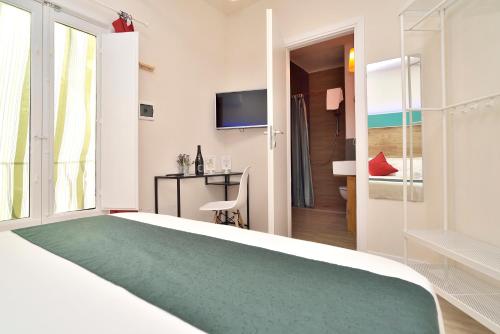 a hotel room with a large bed and a desk at Modica Old Town Rooms in Modica