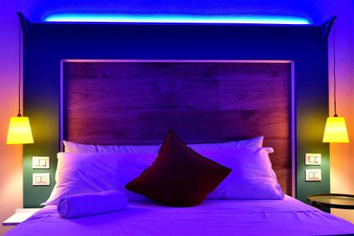 a bedroom with a bed with purple lighting at Modica Old Town Rooms in Modica