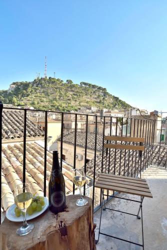a table with a bottle of wine and two glasses at Modica Old Town Rooms in Modica