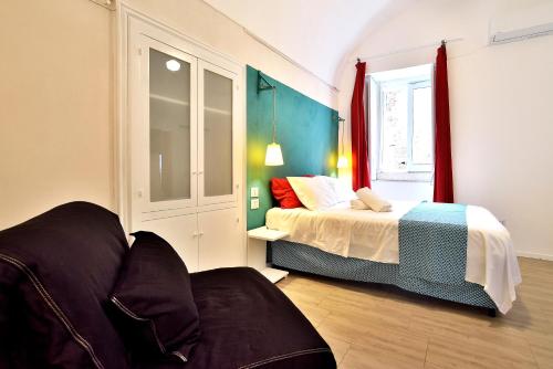 a bedroom with a bed and a couch in it at Modica Old Town Rooms in Modica