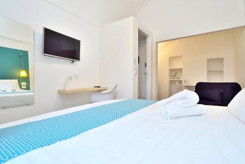 a white bedroom with a large bed with towels on it at Modica Old Town Rooms in Modica