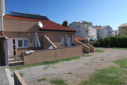 a house with an umbrella on the side of it at Family Apartment in Baška