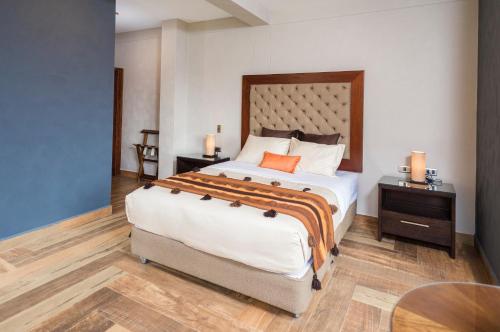a bedroom with a large bed and a table at Intiterra Apart Hotel Villas in Urubamba