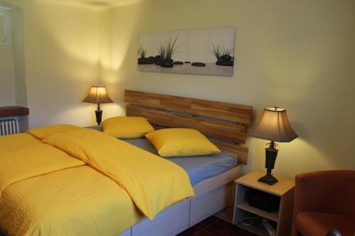 una camera da letto con un letto con lenzuola gialle e due lampade di Casa Ortensia a Magadino