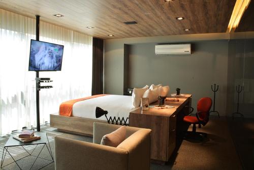a hotel room with a bed and a desk and chairs at Hotel Park Nilo Reforma in Mexico City