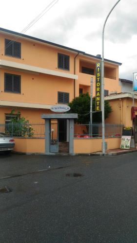 a yellow building with a sign in front of it at B&B Madau in Samughèo