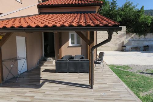 a patio with chairs under a roof at Family Apartment in Baška