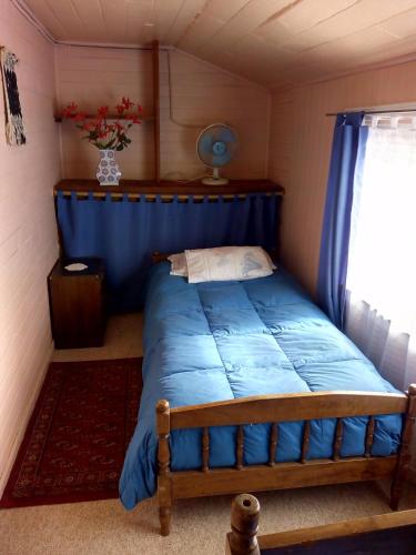 a bedroom with a blue bed in a room at Hospedaje Alicia Acuna in Quepe