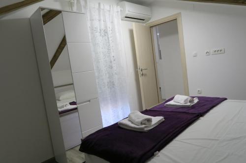 1 dormitorio con 1 cama con toallas en Family Apartment, en Baška