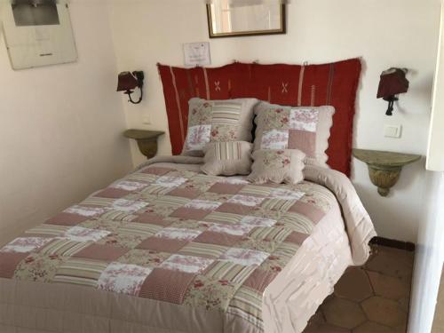 a bedroom with a bed with a red headboard at Maison de pêcheur à Porquerolles in Porquerolles