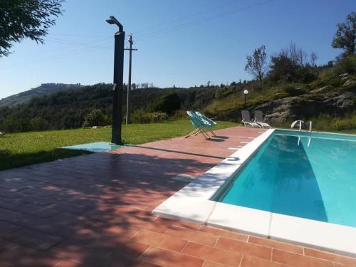 a blue swimming pool with a chair next to it at Il Cerro Agriturismo Zagarese in Fuscaldo