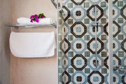 a bathroom with a towel rack and a shower at Nostos Studios in Aegiali