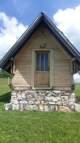 a small building with a door in the grass at Kanjon Uvac in Sjenica
