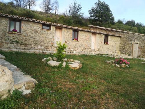 a stone house with a grass yard in front of it at Il Cerro Agriturismo Zagarese in Fuscaldo