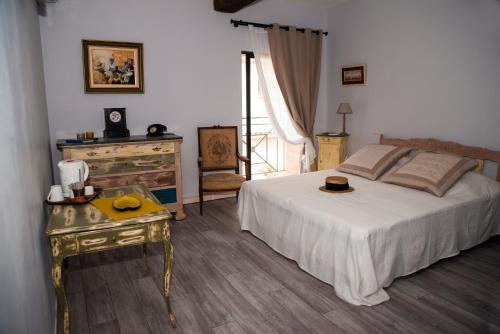 a bedroom with a bed and a dresser and a table at Le Clos des Aramons in Bernis