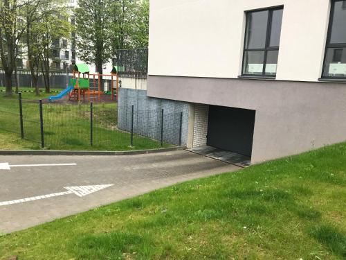 a building with a garage next to a playground at Near Ozas in Vilnius