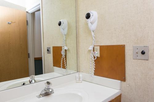 a bathroom with a sink and a phone on the wall at Commodores Inn in Stowe