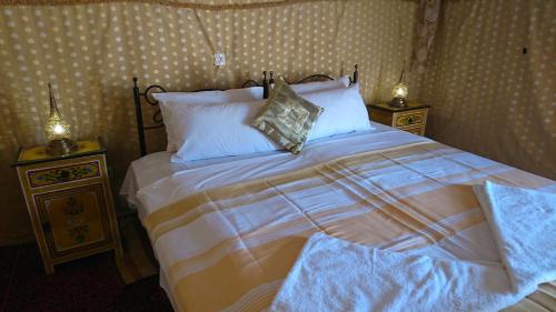 a bedroom with a large bed with two night stands at Morocco Deluxe Camp - Assif n'Itrane in Lac Yasmins