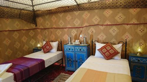 a room with two beds in a room with a wall at Morocco Deluxe Camp - Assif n'Itrane in Lac Yasmins
