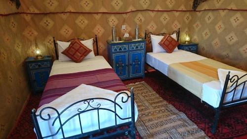 two beds in a room with blue furniture at Morocco Deluxe Camp - Assif n'Itrane in Lac Yasmins