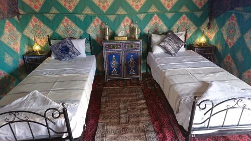 two beds in a room with green walls at Morocco Deluxe Camp - Assif n'Itrane in Lac Yasmins