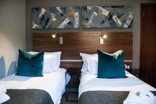 ブルームフォンテーンにある@Greys Guesthouseのホテルルーム ベッド2台 ブルーピロー付