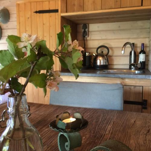 a vase with flowers on a table with a candle at Vrijzicht in Ochten