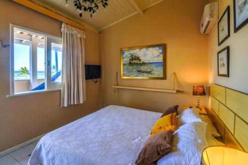 a bedroom with a white bed and a window at Pousada Via Brasil in Morro de São Paulo