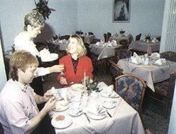 Dos mujeres sentadas en una mesa en un restaurante en Hotel zur Eisenbahn, en Rodgau