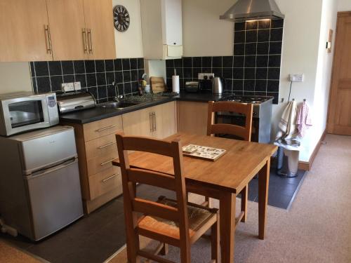 a kitchen with a wooden table and chairs in it at The Cottage in Belford