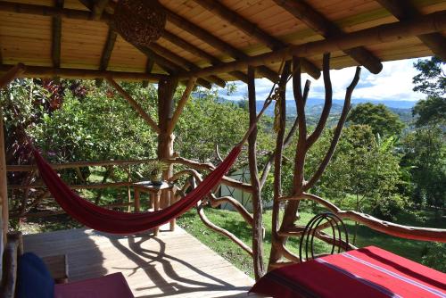 a hammock on a porch with a view at Hotel La Casa de Francois in San Agustín