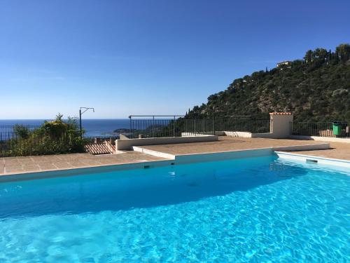a swimming pool with a view of the ocean at La Villa Cavalaire in Cavalaire-sur-Mer