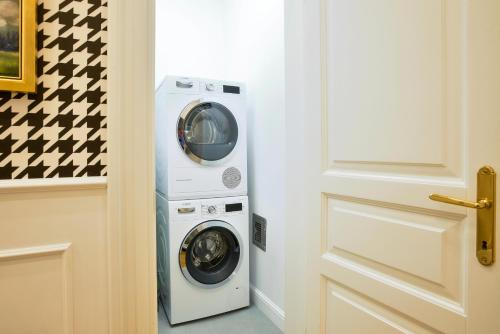 a laundry room with a washer and dryer next to a door at Broadway Residence in Budapest