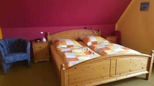 ベンサージールにあるWohnung 4 @ Haus Annegreteのベッドルーム(木製ベッド1台、青い椅子付)