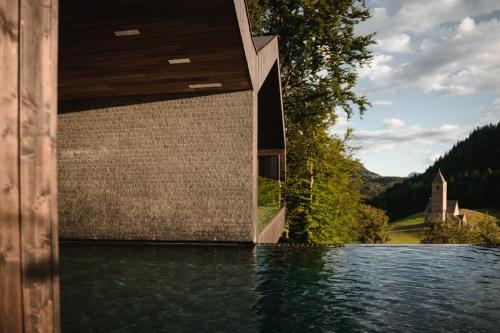 a house on a body of water at Miramonti Boutique Hotel in Avelengo